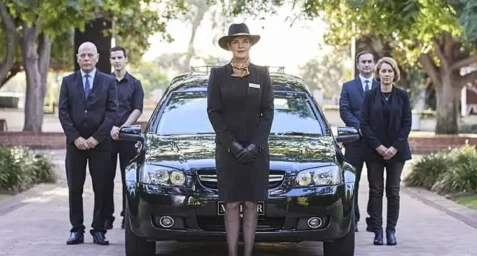 A funeral director in from of the Mayfair hearse at the commencement of a perth cremation service